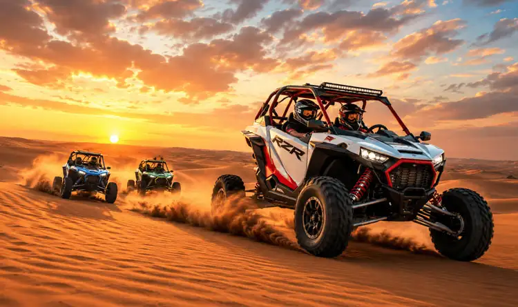 Three off-road dune buggies racing across the rolling golden sand dunes of the Abu Dhabi desert under a vibrant orange sunset sky.